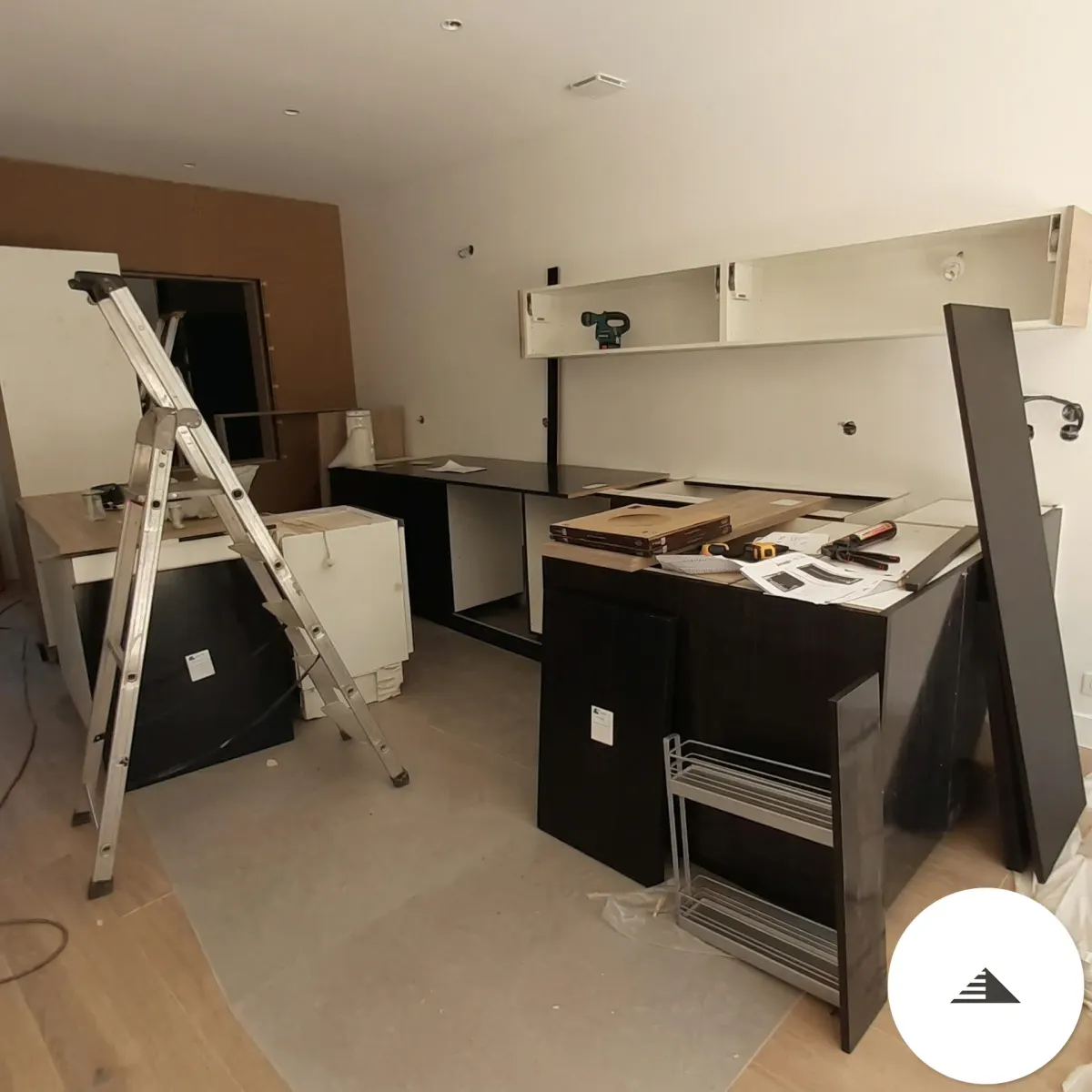 Cuisines sur mesure — Chantier de pose cuisine noire et blanche, caissons en cours d'installation, vue large de la pièce avec escabeau à Bastia | Gonzalez Agencement