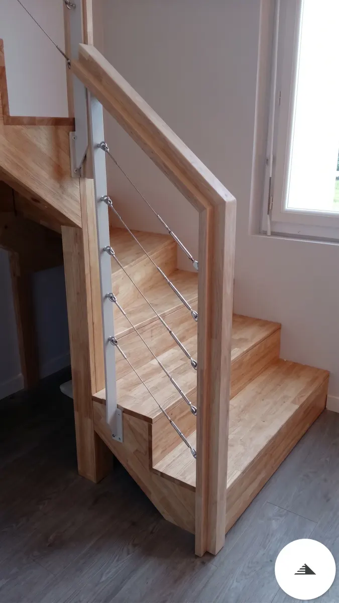 Escaliers sur mesure — Base d'escalier en bois massif naturel clair avec garde-corps à câbles inox tendus sur montants bois, vue en contre-plongée à Bordeaux | Gonzalez Agencement