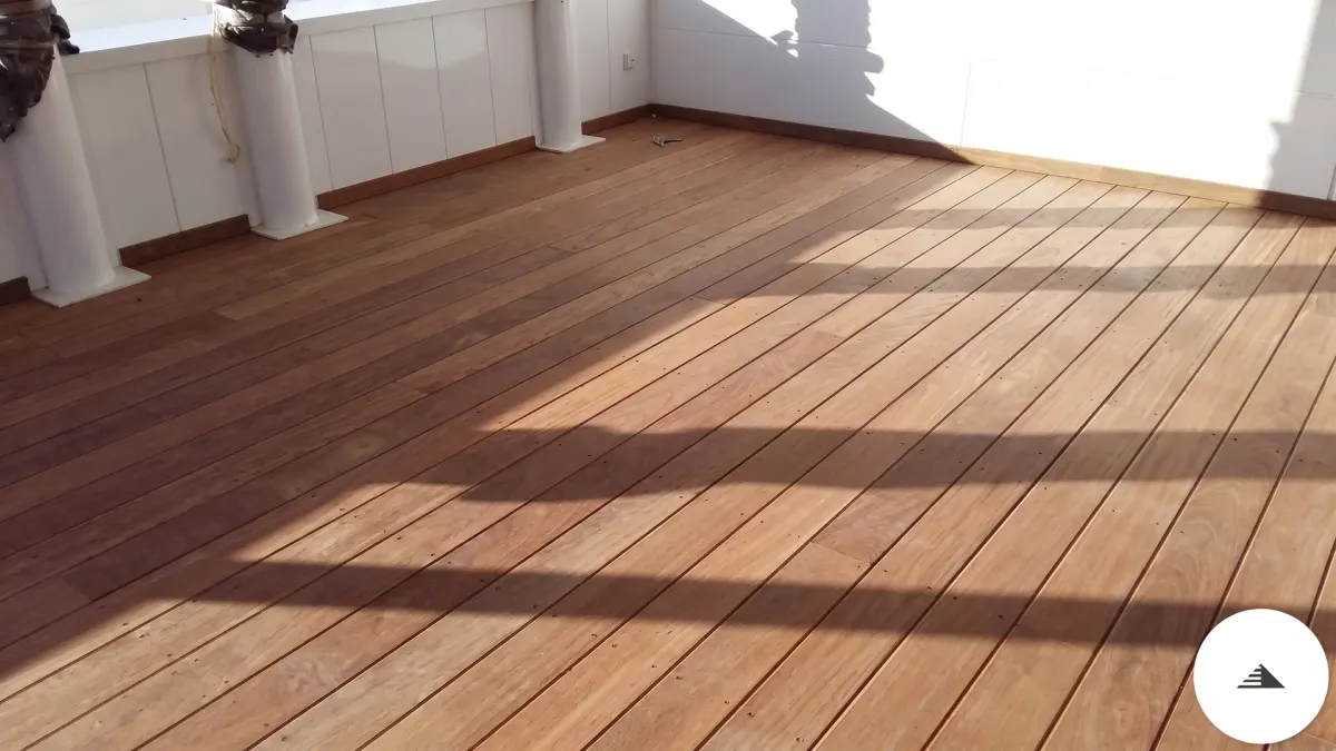 Terrasses sur mesure — Vue en diagonale des lames bois exotique de la terrasse, ombres portées géométriques et piliers blancs en fond à Bordeaux | Gonzalez Agencement