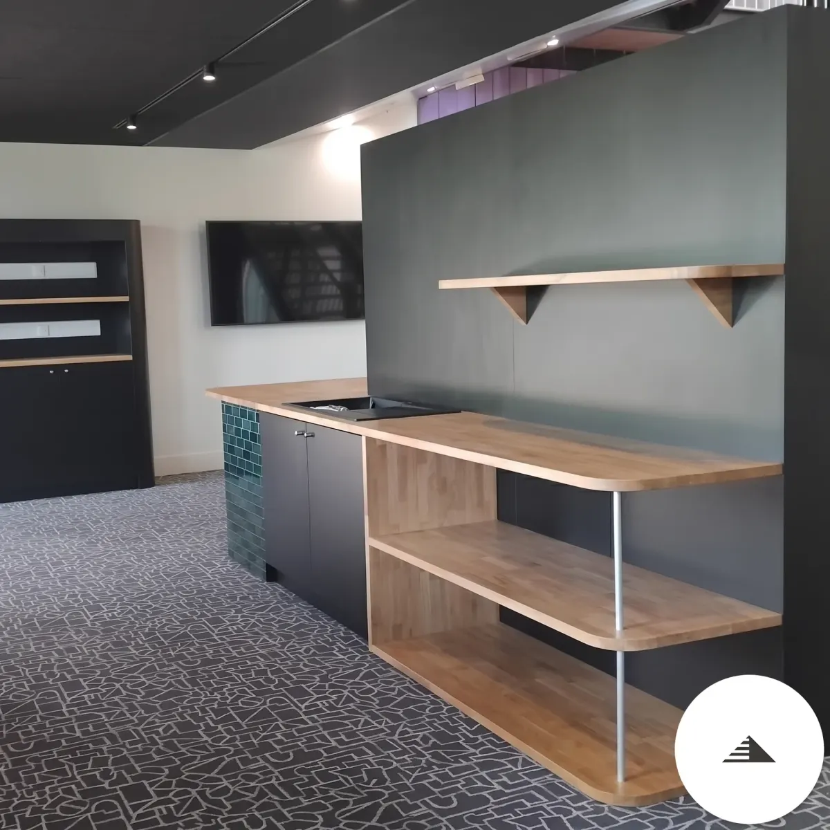 Cuisines sur mesure — Vue latérale des étagères chêne sur consoles noires triangulaires et prolongement du comptoir bois, espace co-working à Bordeaux | Gonzalez Agencement