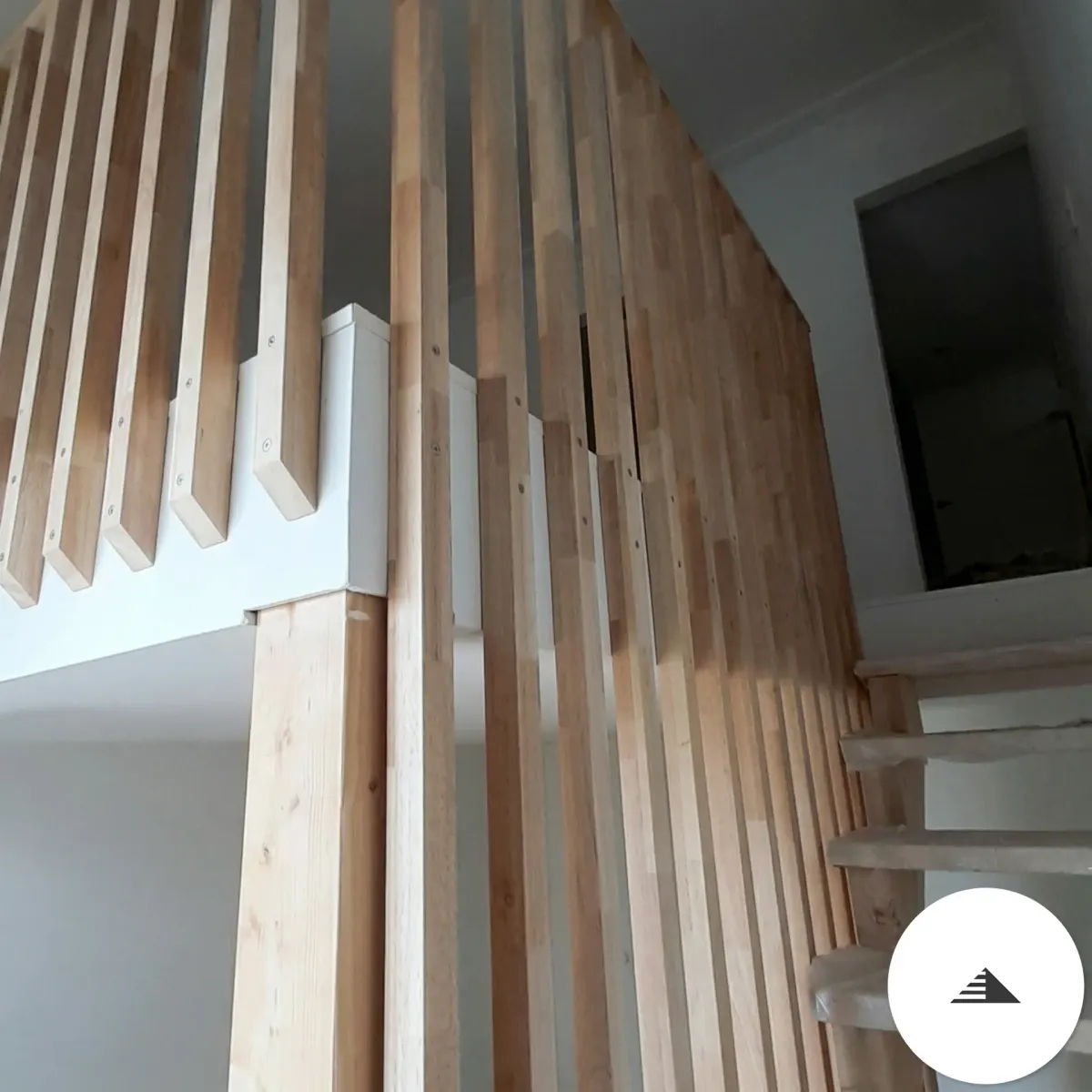 Escaliers sur mesure — Claustra lames verticales bois clair avec fixations métal blanc, vue rapprochée depuis l'escalier béton, chantier en cours à Le Haillan | Gonzalez Agencement