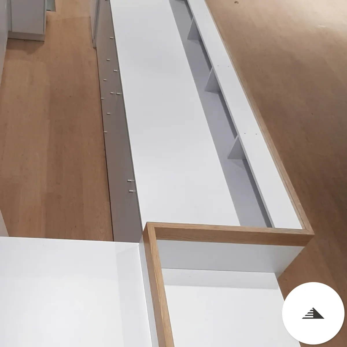 Meubles sur mesure — Vue en plongée du comptoir, plan de travail blanc et intérieur à compartiments avec bord bois chaud, fabrication atelier à Le Pian Médoc | Gonzalez Agencement