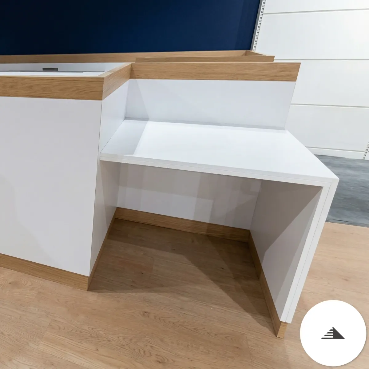 Meubles sur mesure — Détail du retour de la banque d'accueil, partie ouverte en U avec bordure chêne, structure blanche, en atelier à Le Pian Médoc | Gonzalez Agencement