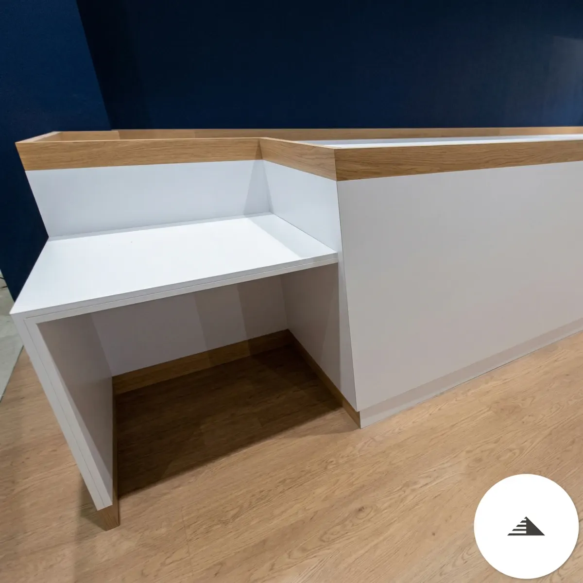 Meubles sur mesure — Angle de la banque d'accueil vue de face, niche intérieure ouverte et dessus chêne naturel, laqué blanc, en atelier à Le Pian Médoc | Gonzalez Agencement