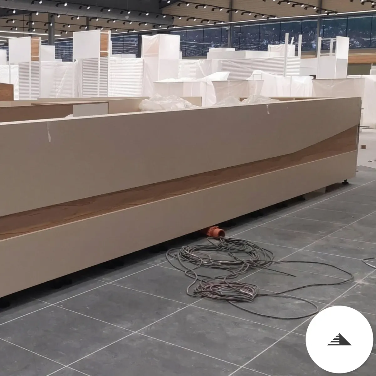 Meubles sur mesure — Vue de face de la grande banquette beige et bois veiné dans le magasin en cours d'aménagement, plan large à Le Pian Médoc | Gonzalez Agencement