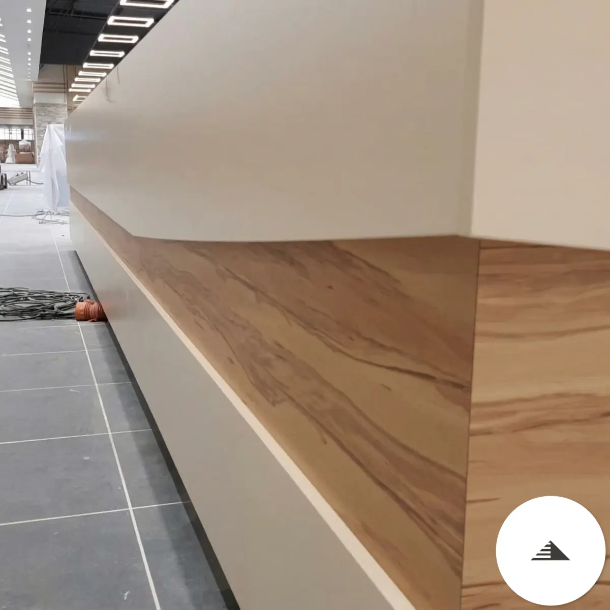 Meubles sur mesure — Gros plan sur le liseré en bois veiné warm de la banquette, veine naturelle prononcée, contraste avec le laqué crème à Le Pian Médoc | Gonzalez Agencement