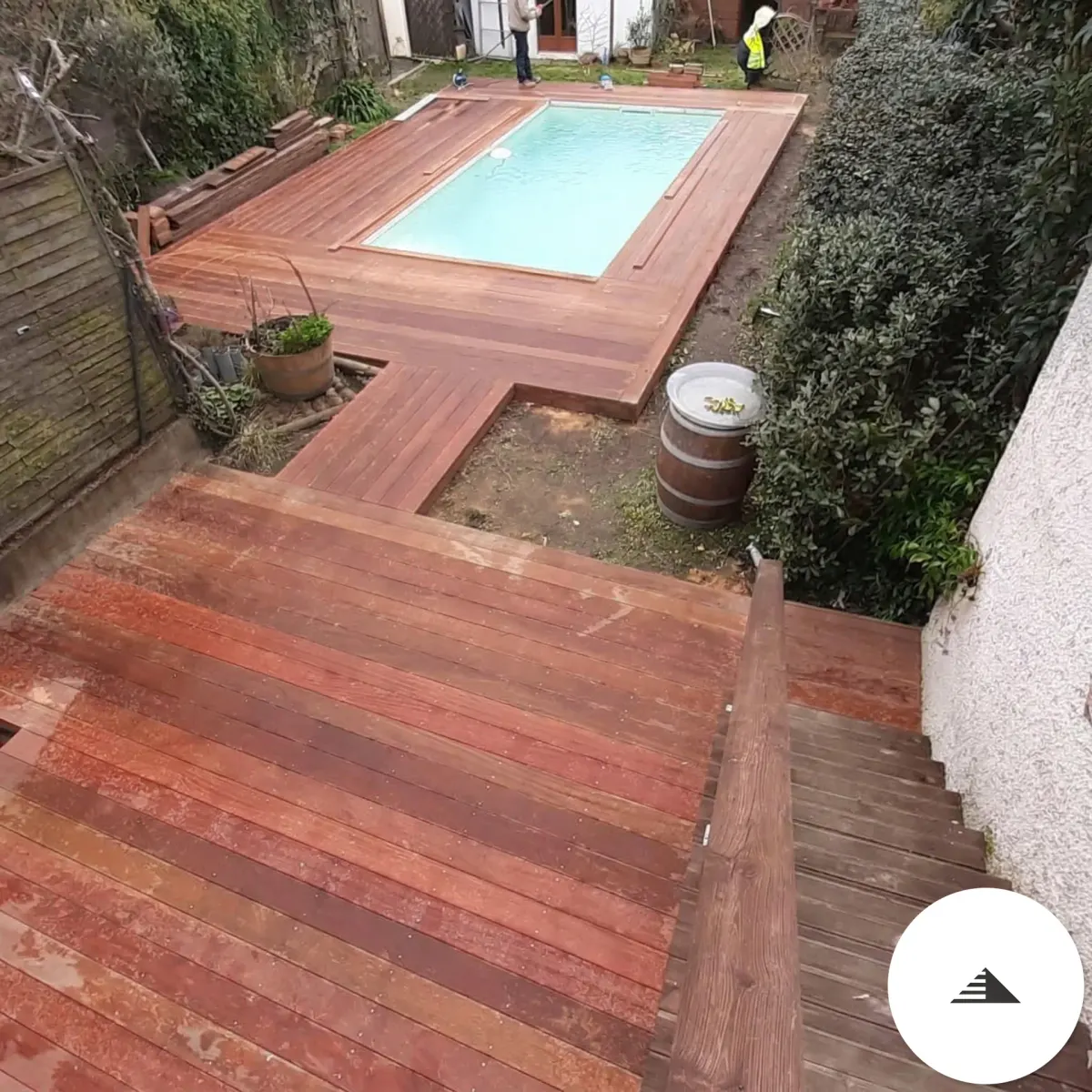 Terrasses sur mesure — Vue en plongée d'une terrasse bois exotique rouge-brun autour d'une piscine rectangulaire avec escalier latéral intégré à Bordeaux | Gonzalez Agencement