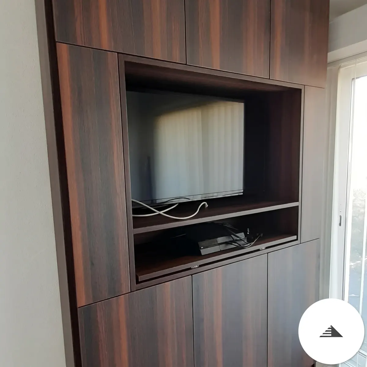 Meubles sur mesure — Colonne pleine hauteur avec niche TV centrale intégrée, rangements hauts et bas façade wengé foncé, vue en angle à Bordeaux | Gonzalez Agencement