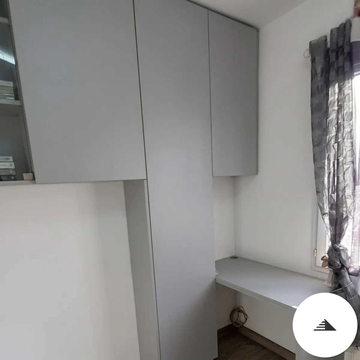 Aménagements sur mesure — Bureau intégré plan blanc sous rangements suspendus et armoire haute, vue de l'angle fenêtre avec rideau à Bordeaux | Gonzalez Agencement