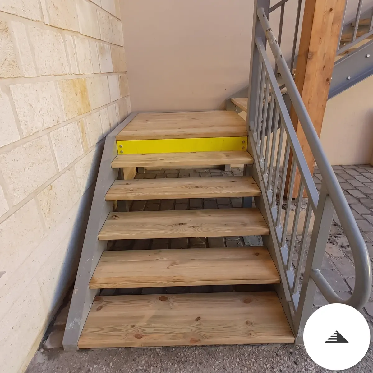 Escaliers sur mesure — Vue en montée des marches bois clair à nœuds apparents sur structure acier gris, contexte extérieur mur pierres à Bordeaux | Gonzalez Agencement