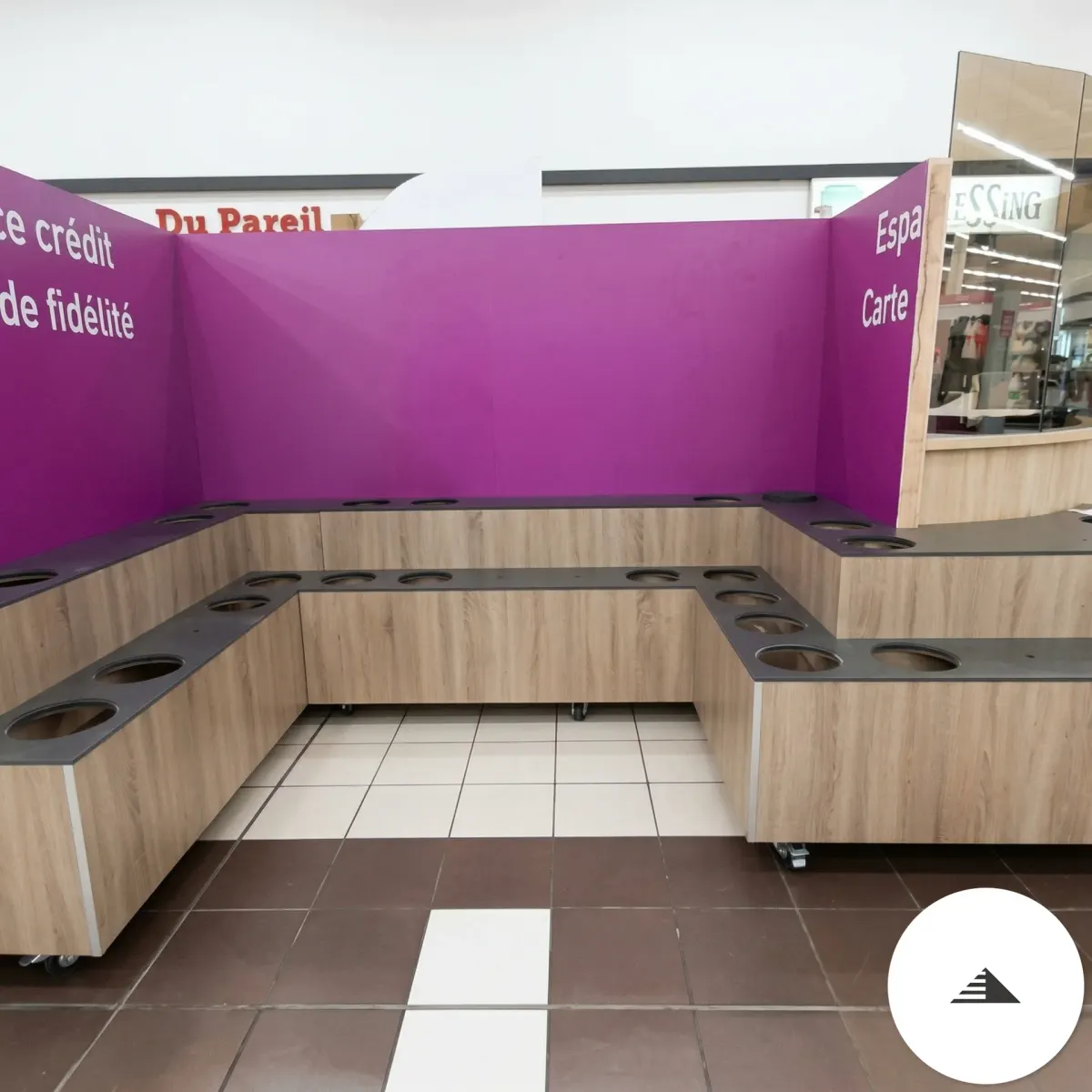Agencement sur mesure — Meubles comptoir bois clair chêne en U avec plans noirs perforés, vue d'ensemble espace commercial Galerie E.Leclerc au Pian Médoc | Gonzalez Agencement