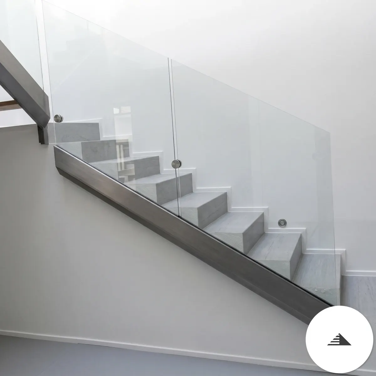 Escaliers sur mesure — Garde-corps en verre trempé transparent avec montants et sabots inox sur escalier intérieur béton gris, vue latérale en descente à Bordeaux | Gonzalez Agencement