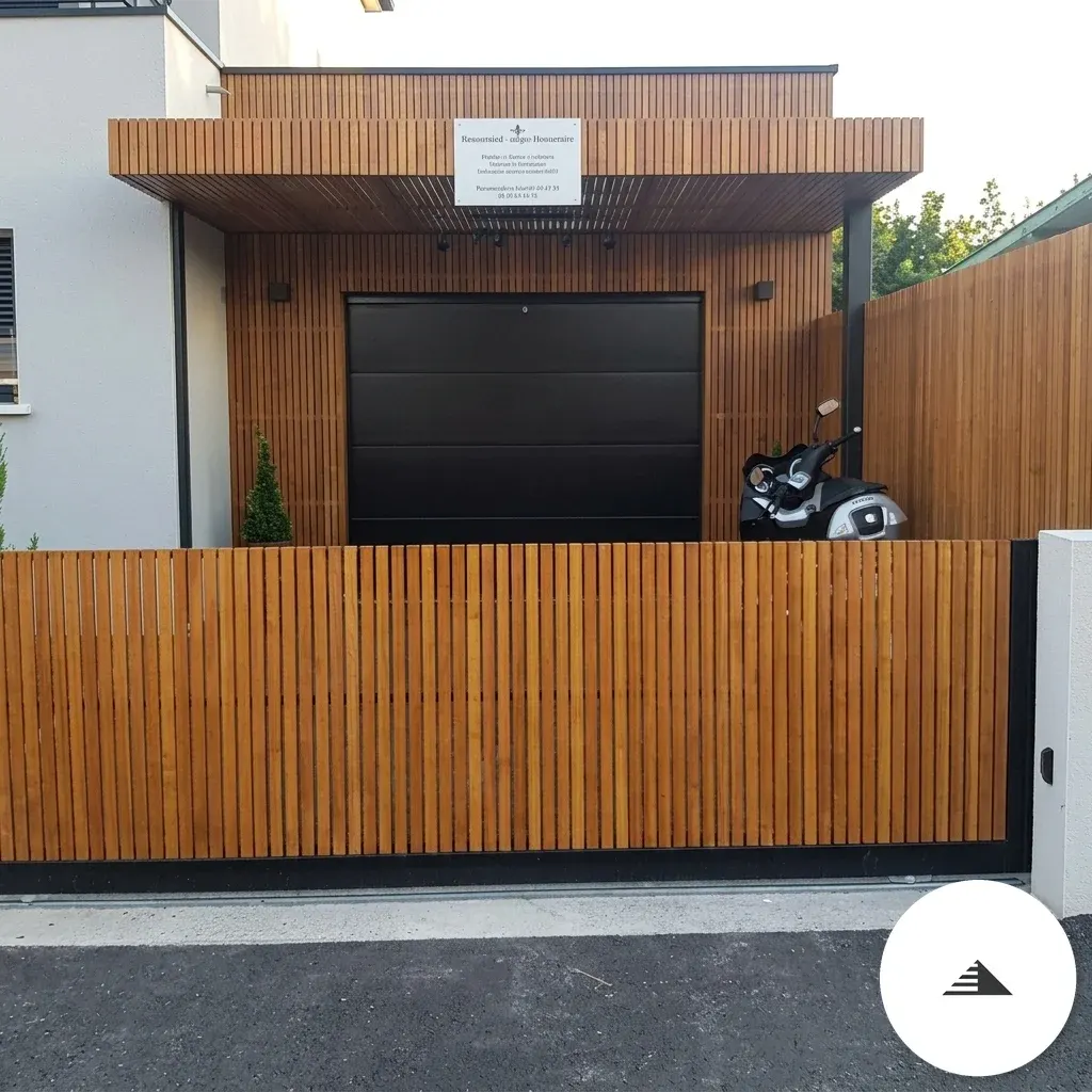 Bardage sur mesure — Portail coulissant et façade de garage habillés de lames bois verticales teinte miel, encadrement métal noir, vue frontale à Bordeaux | Gonzalez Agencement