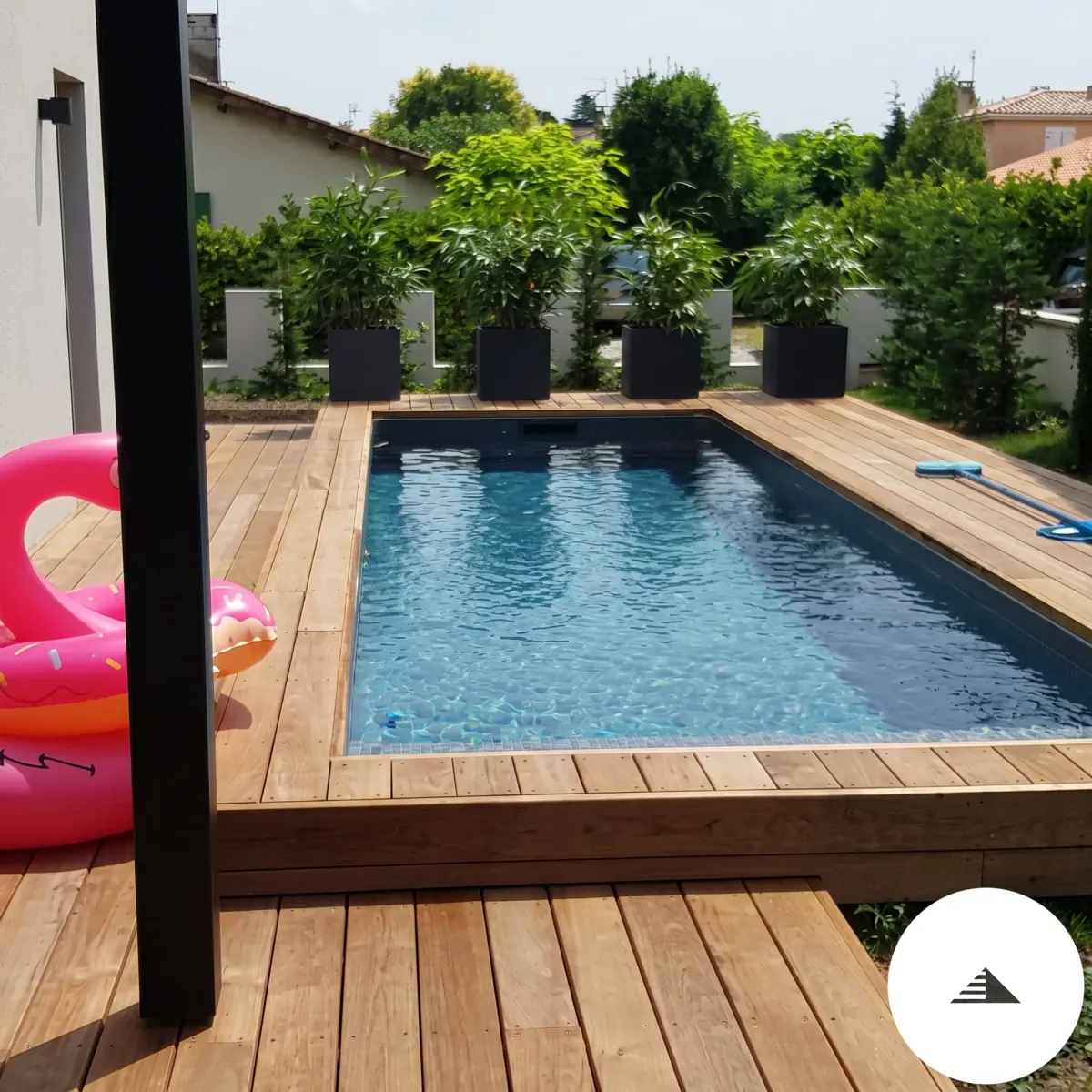 Aménagements sur mesure — Terrasse en lames bois naturel clair ceinturant une piscine rectangulaire, vue en plongée légère depuis la pergola à Bordeaux | Gonzalez Agencement