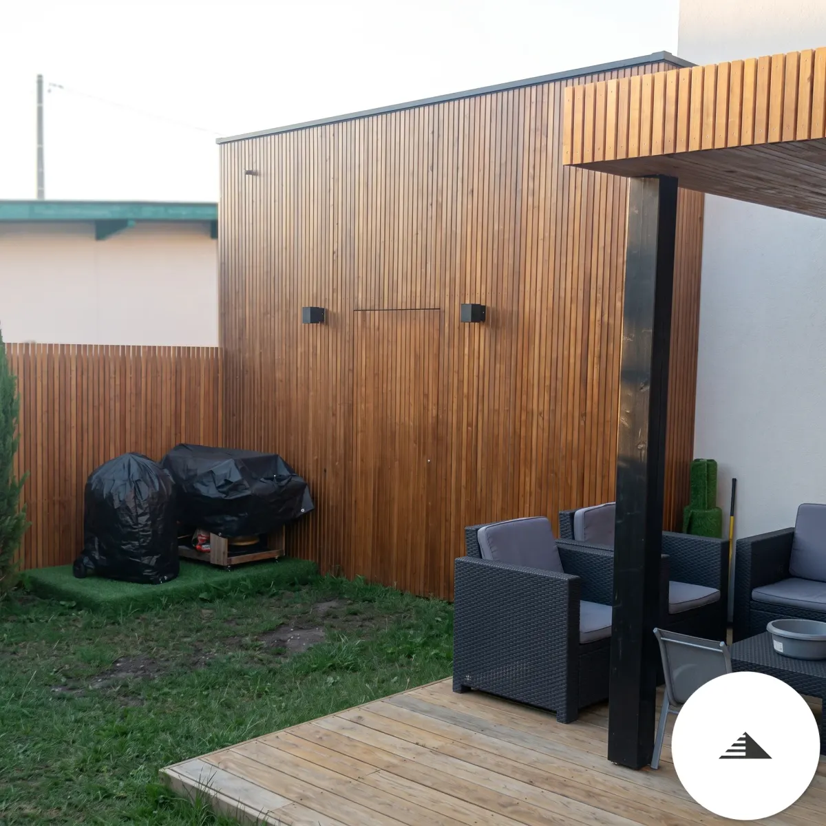 Aménagements sur mesure — Bardage claustra bois vertical en fond de jardin, terrasse bois et pergola avec salon de jardin au premier plan à Bordeaux | Gonzalez Agencement