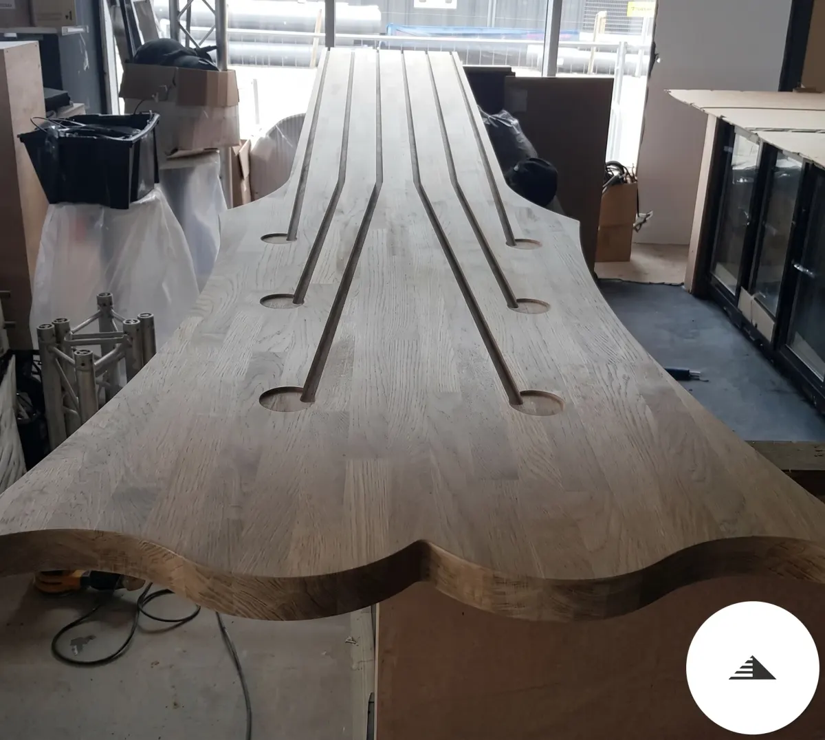Agencement sur mesure — Plateau de comptoir en chêne massif brut avec silhouette et rainures décoratives en tête de guitare, phase de fabrication en atelier à Bordeaux | Gonzalez Agencement