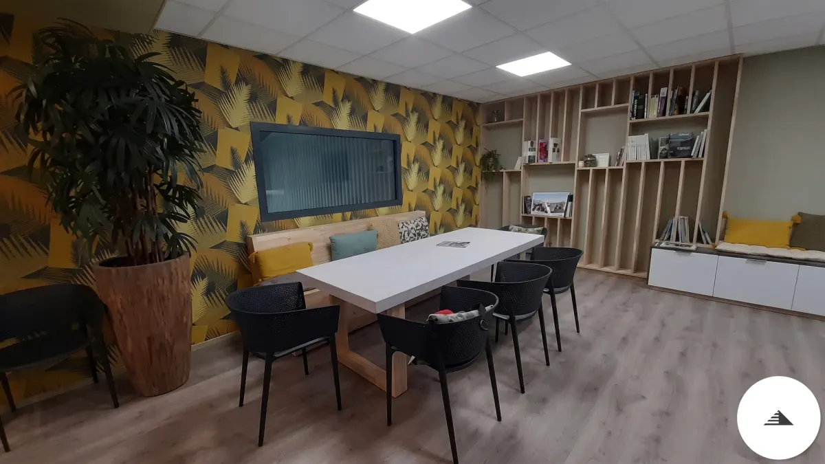 Agencement sur mesure — Salle de réunion/détente avec table centrale blanche, bibliothèque bois naturel ouverte et papier peint tropical, vue d'ensemble à Bordeaux | Gonzalez Agencement