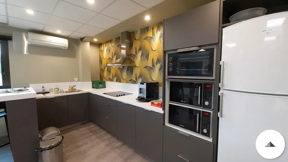 Agencement sur mesure — Cuisine en équerre gris anthracite mat avec colonne four intégrée et plan de travail blanc, espace co-working à Bordeaux | Gonzalez Agencement