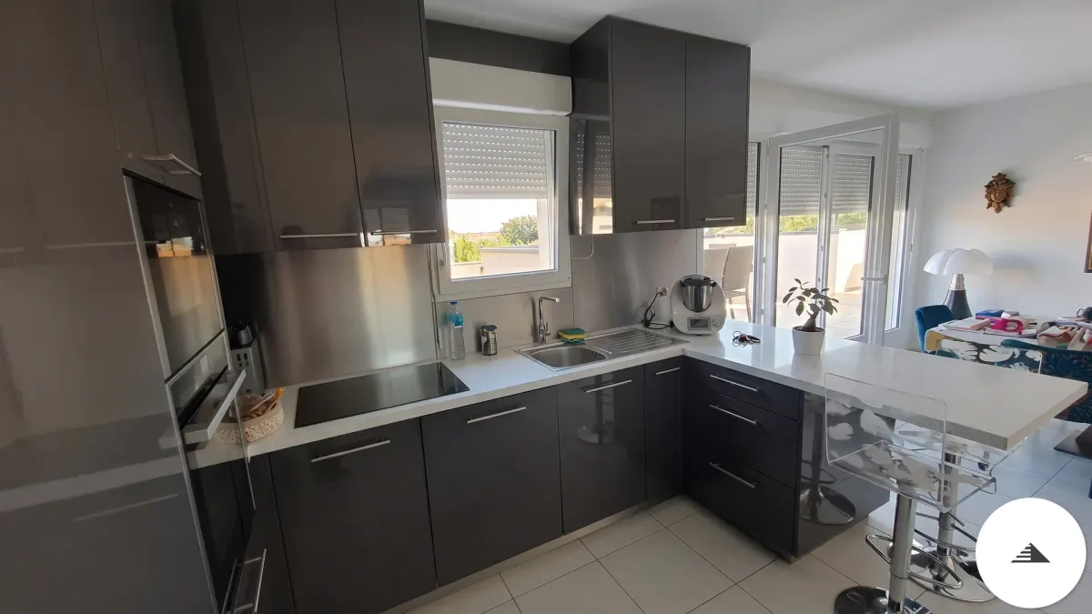 Cuisines sur mesure — Zone évier et plaque de cuisson de la cuisine anthracite brillant sur mesure, vue en L depuis l'angle de l'îlot à Bordeaux | Gonzalez Agencement