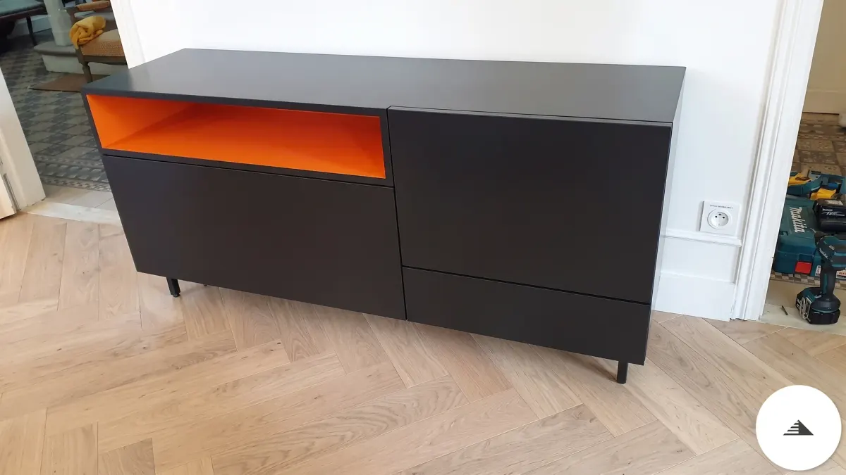 Meubles sur mesure — Buffet laqué mat noir avec niche ouverte orange vif contrastée, pieds fins noirs et façades sans poignée, vue frontale à Bordeaux | Gonzalez Agencement